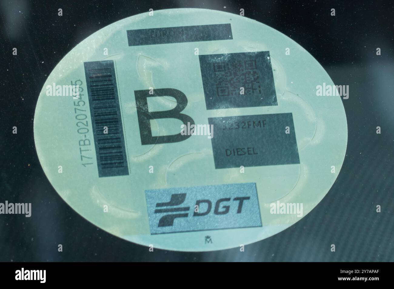 Environmental label to classify vehicles according to their energy efficiency affixed to the windscreen of a car. Yellow B Stock Photo