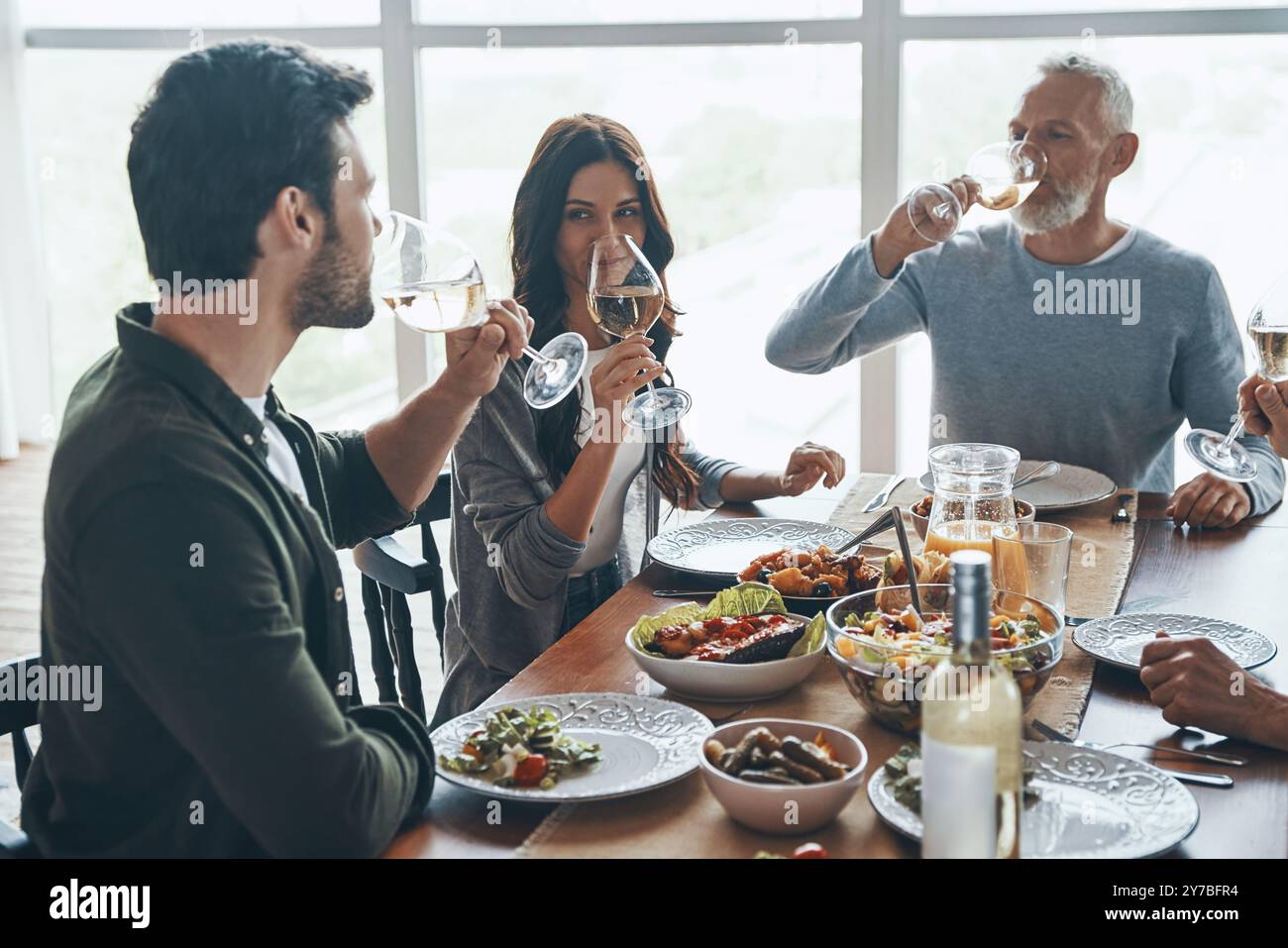 Happy multi-generation family drinking wine while having dinner together Stock Photo