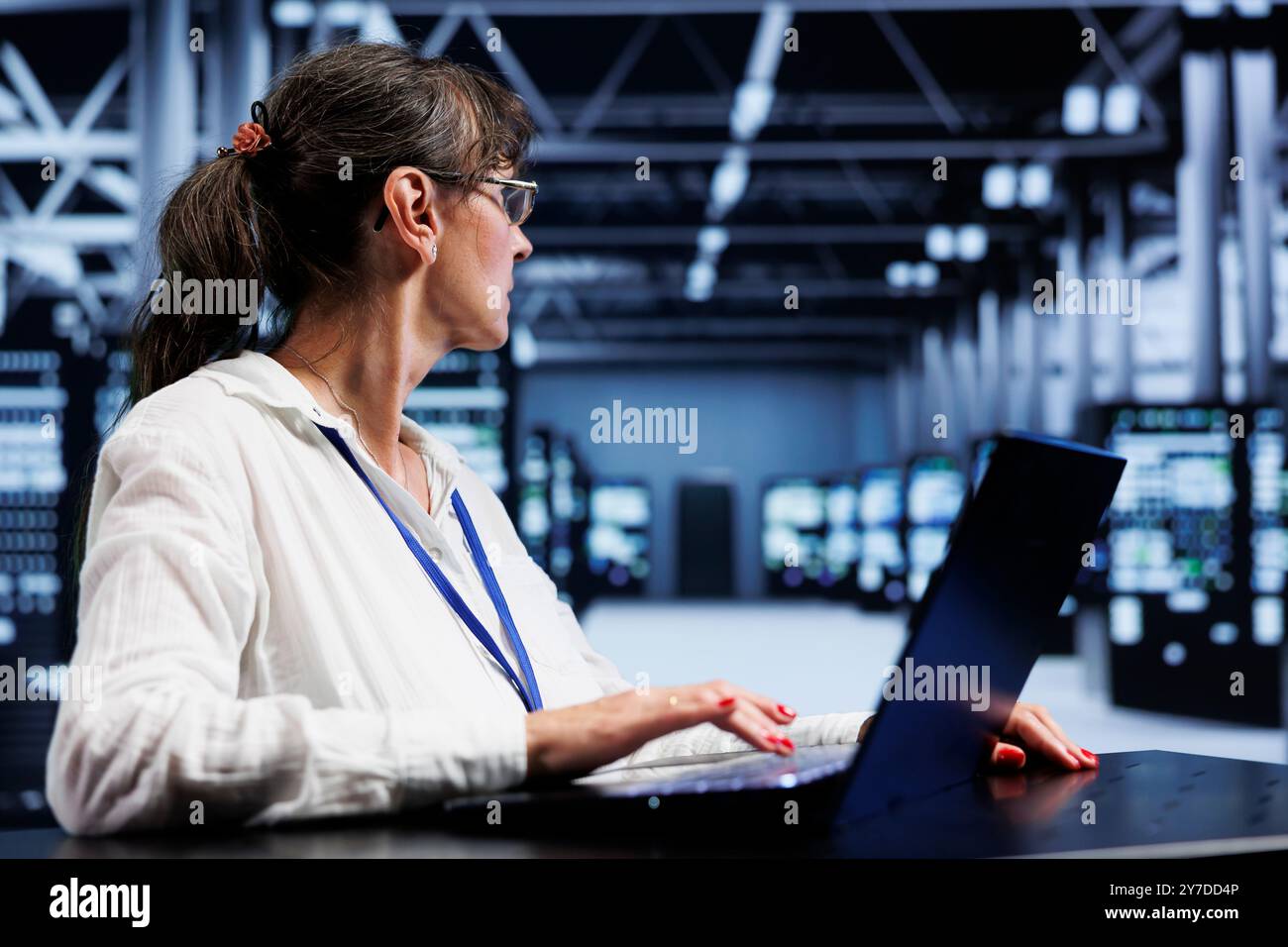 Old proficient electrician inside high tech facility providing computing resources needed for AI to process extensive datasets for training. Server room storing data used for machine learning Stock Photo