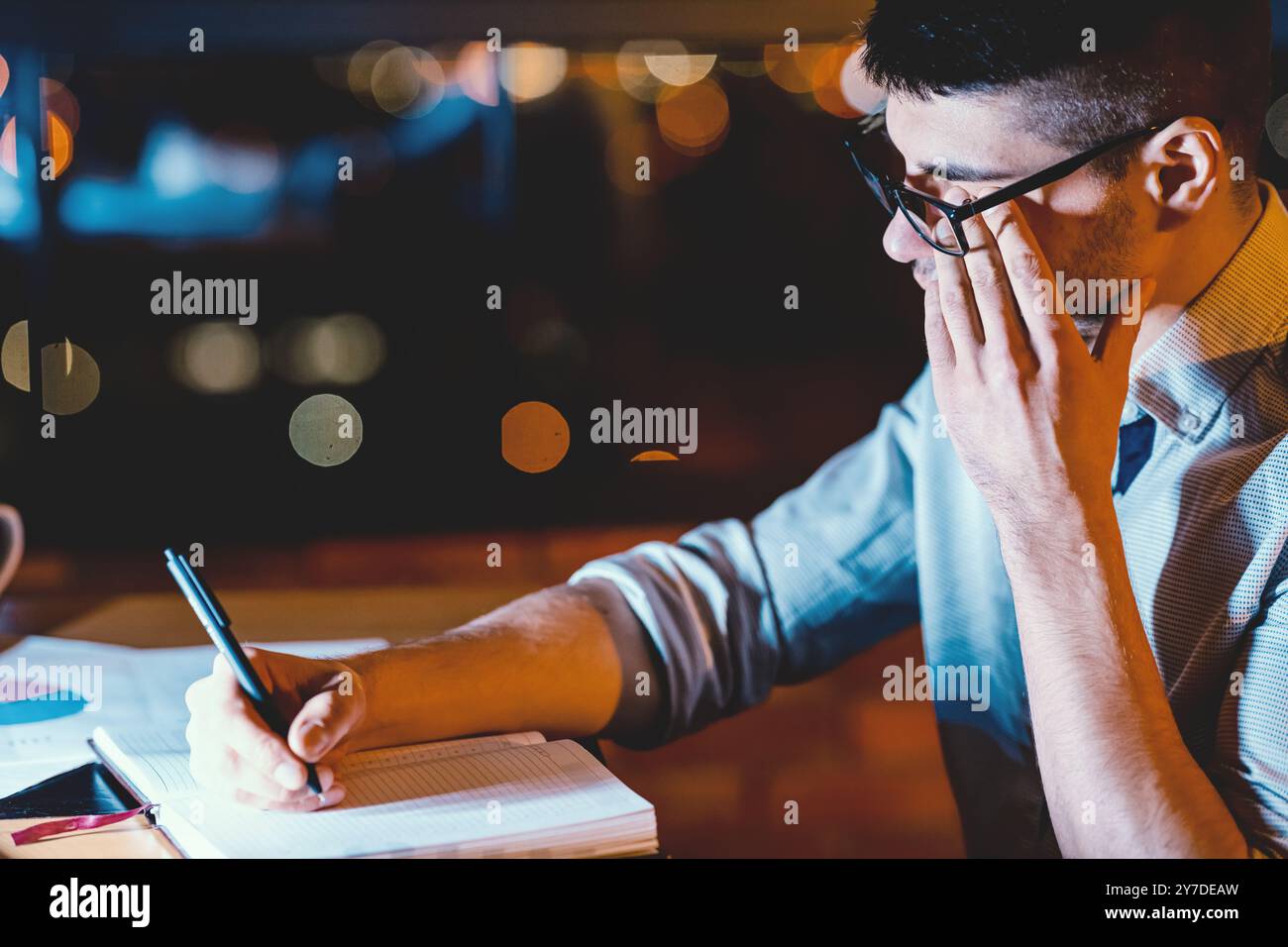 Man Touching Aching Eye Working In Dark Office Room Stock Photo