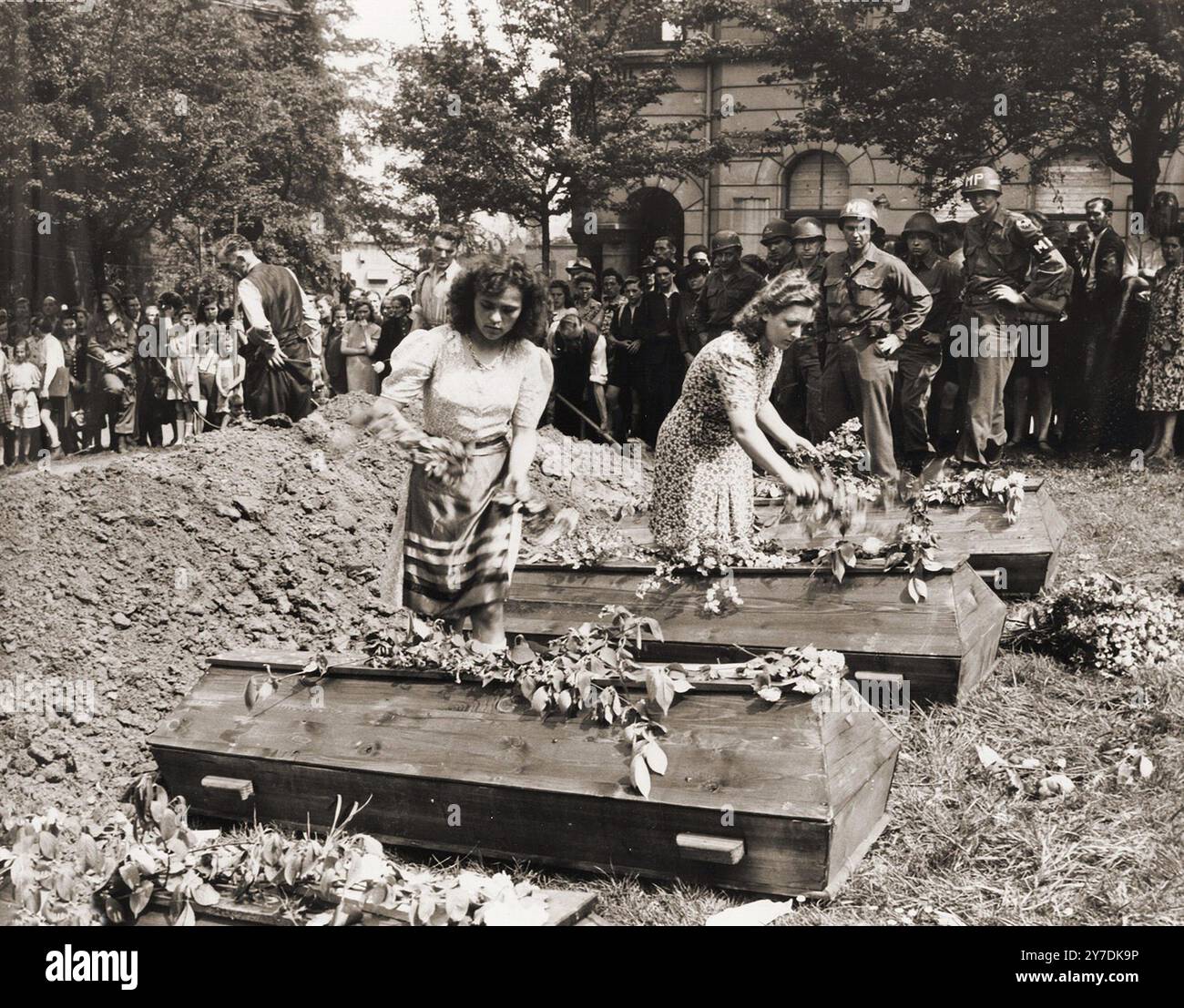 Nazi Flower German girls place flowers on the coffins of seven Russian victims hung ...