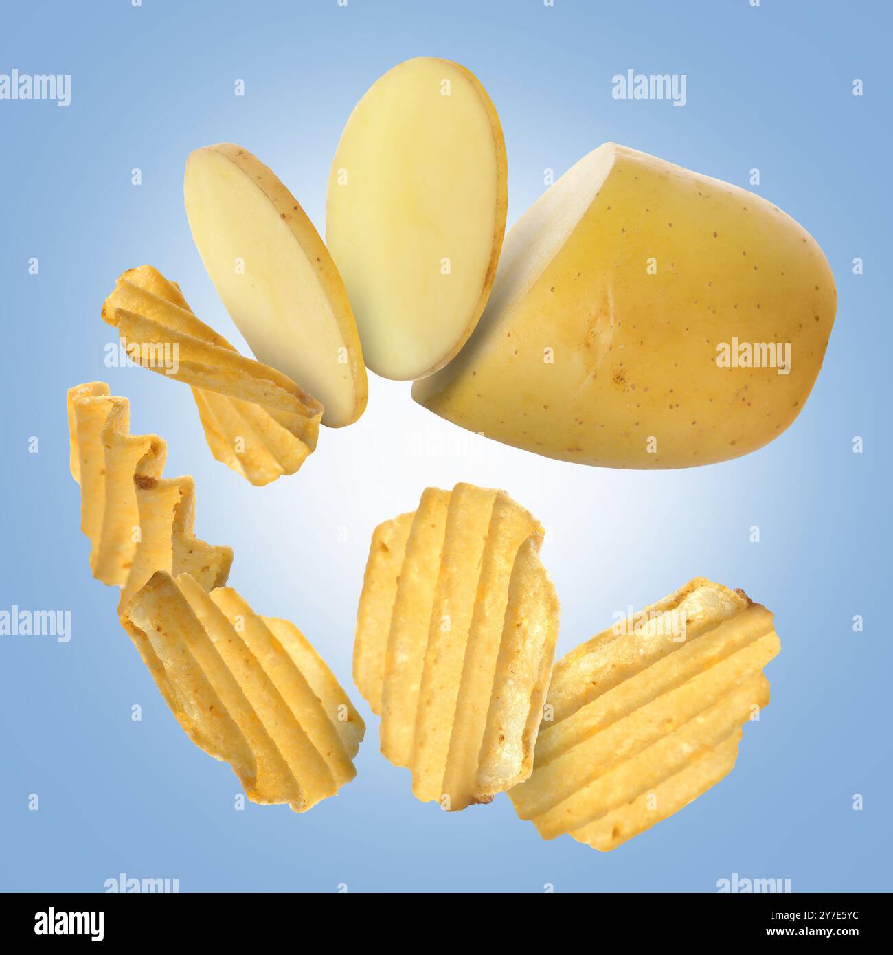 Raw potato turning into tasty crispy chips in air on blue gradient ...