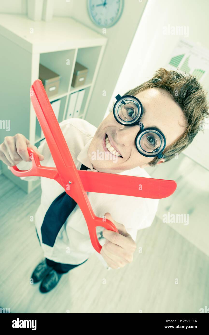 Gleefully handling huge scissors, he embodies the harsh reality of ...