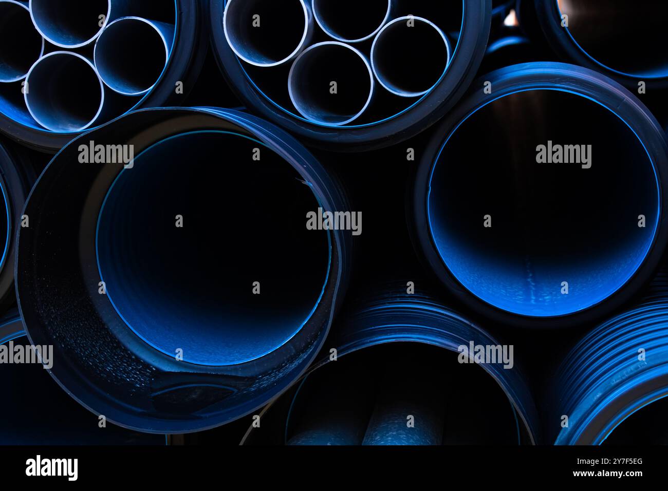 Backgrounds and textures of black and blue PVC pipes stacked on the ...