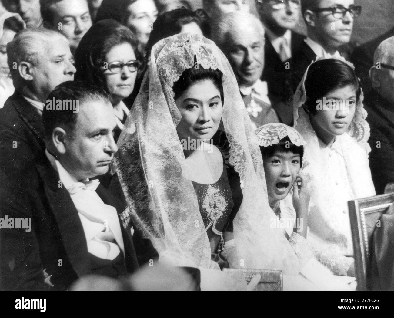 Mrs. Imelda Marcos wife of the Philippine President, sits with her two daughters, Irene (with mouth open) and Imee, to watch Archbishop Julio Rosales of Cebu, Philippines, receive his red 'Biretta' hat from his holiness Pope Paul IV during the consistory ceremony at St. Peter's Hall of Benedictions. Vatican City, Italy - 30th April 1969 Stock Photo