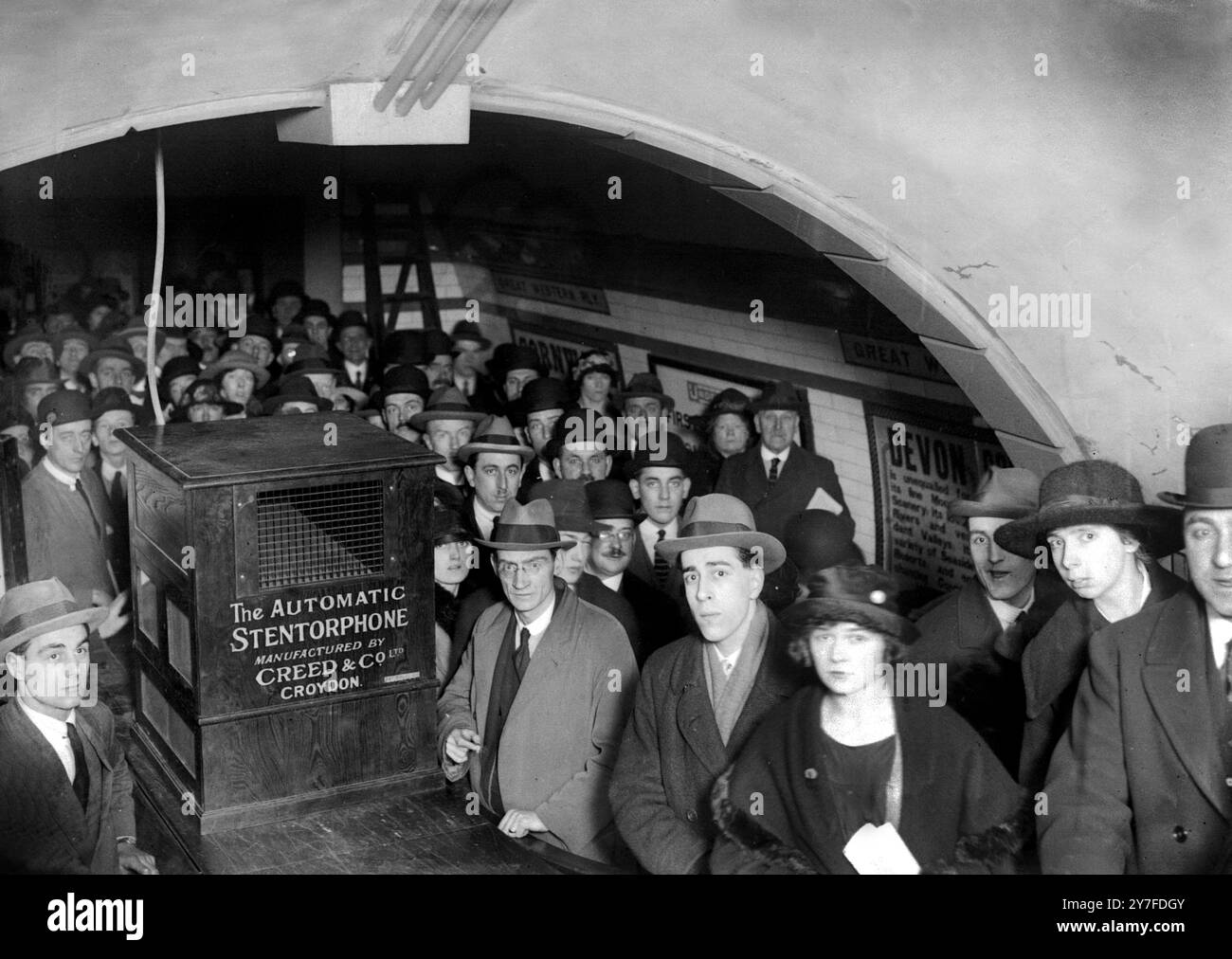 Keep Moving, Please ! The automatic stentorphone installed at Oxford Circus underground station to speed up passengers.  Mr Jas Forsyth (Creed & Co.) with the machine.  27th January 1921. Stock Photo