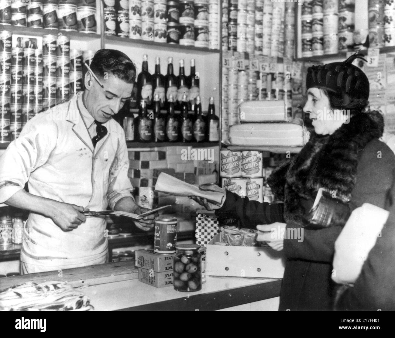 Ration cards were necessary for food, 1947 Manchester (Buying bacon in shop). Stock Photo