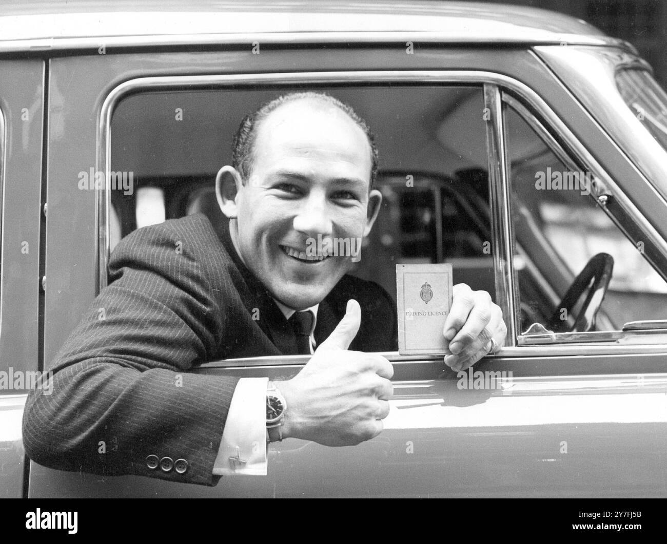 STIRLING MOSS WITH NEW DRIVING LICENCE AFTER YEAR OF DISQUALIFICATION. HE CELEBRATED BY BUYING A NEW FORD ZODIAC SALOON CAR. APRIL 13TH 1960. Stock Photo