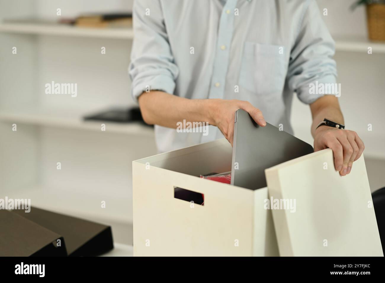 Young male office worker packing belongings in box after being fired ...