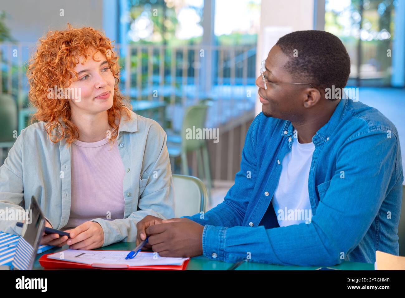Two happy teenage students talking with college notes Stock Photo - Alamy