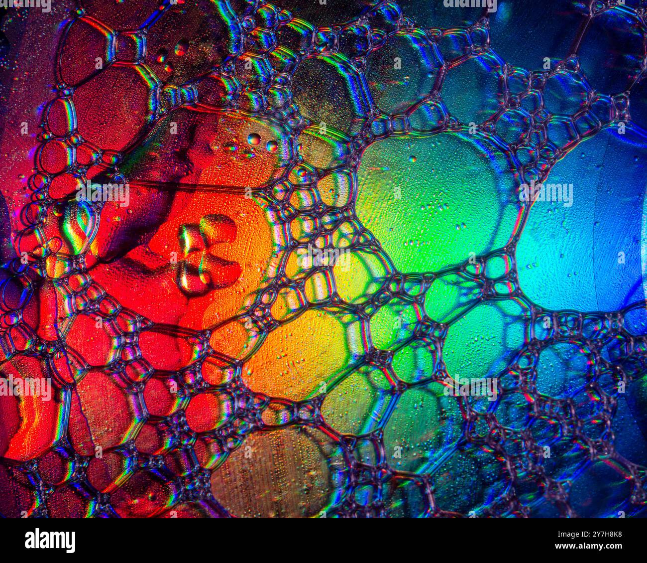 A macro shot showing patterns and colours of oil drops floating on a ...