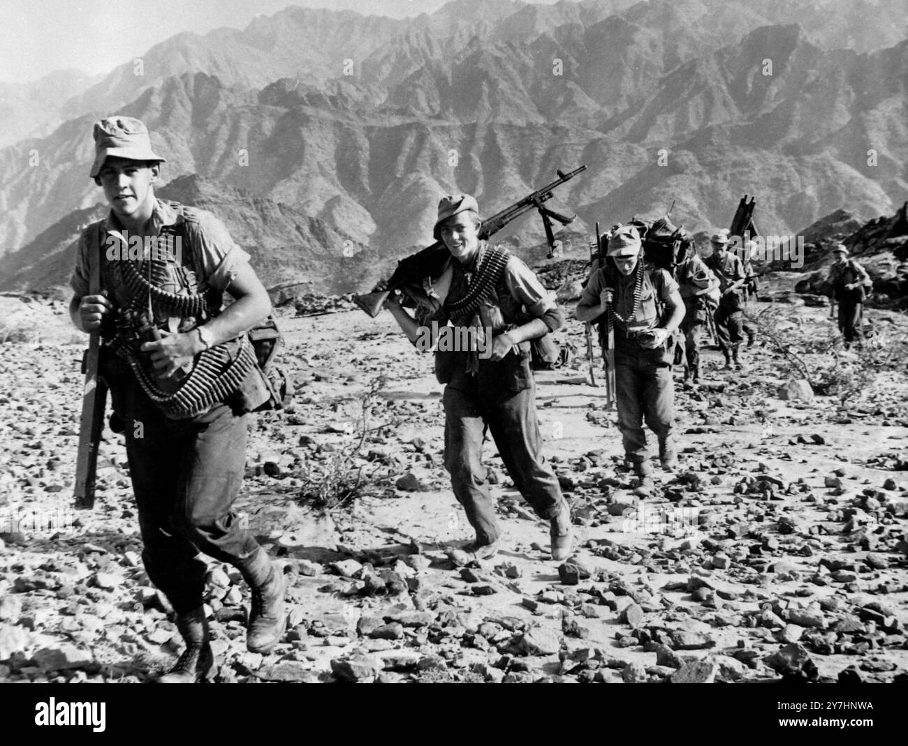 10 MAY 1964  3rd Battalion Para's advance.  Paratroopers of the 3rd Battalion, are shown in advancing across rough terrain in the Radfan area here yesterday. Yesterday, British royal air force planes scattered leaflets on the barren mountains south of the Yemen border, calling on the wild Rebel tribesman to sue for peace.  The leaflet operation followed a week's offensive by British paratroopers and Royal Marines Commandos and South Arabian Federation troops backed with British armoured cars in the barren oven of the Radfan by mountains.  The British Confederation troops are now in command of Stock Photo