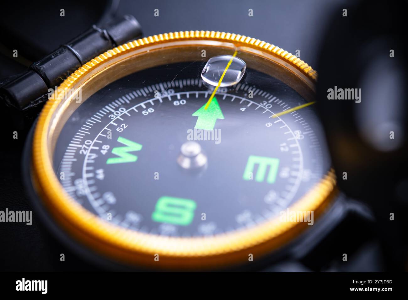 Close-up view of a compass on a black background, symbolizing navigation, adventure, camping, and outdoor exploration. Ideal for travel enthusiasts an Stock Photo