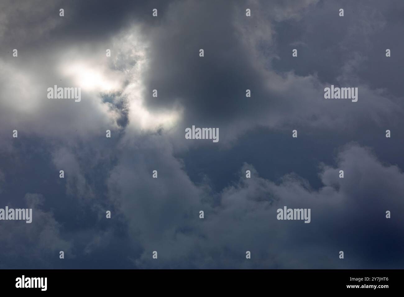Dramatic storm clouds backlit by the sun. Stock Photo