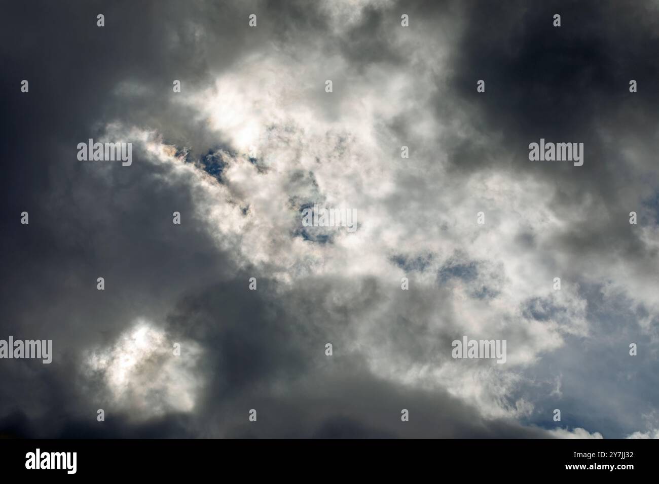 Dramatic storm clouds backlit by the sun. Stock Photo