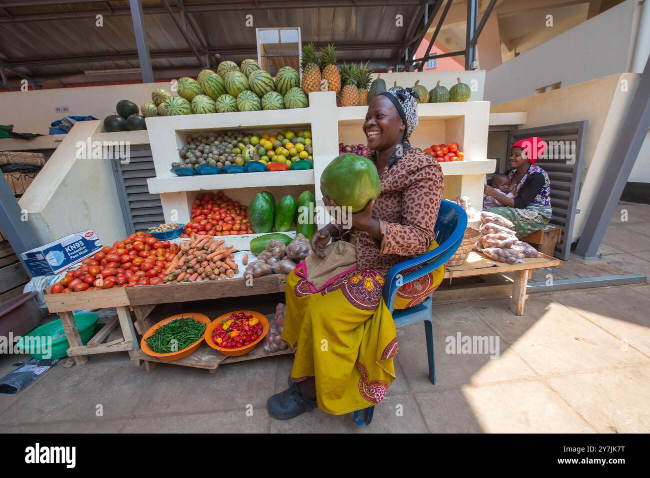 A woman selling fresh vegetables and fruits in Entebbe Market Uganda ...
