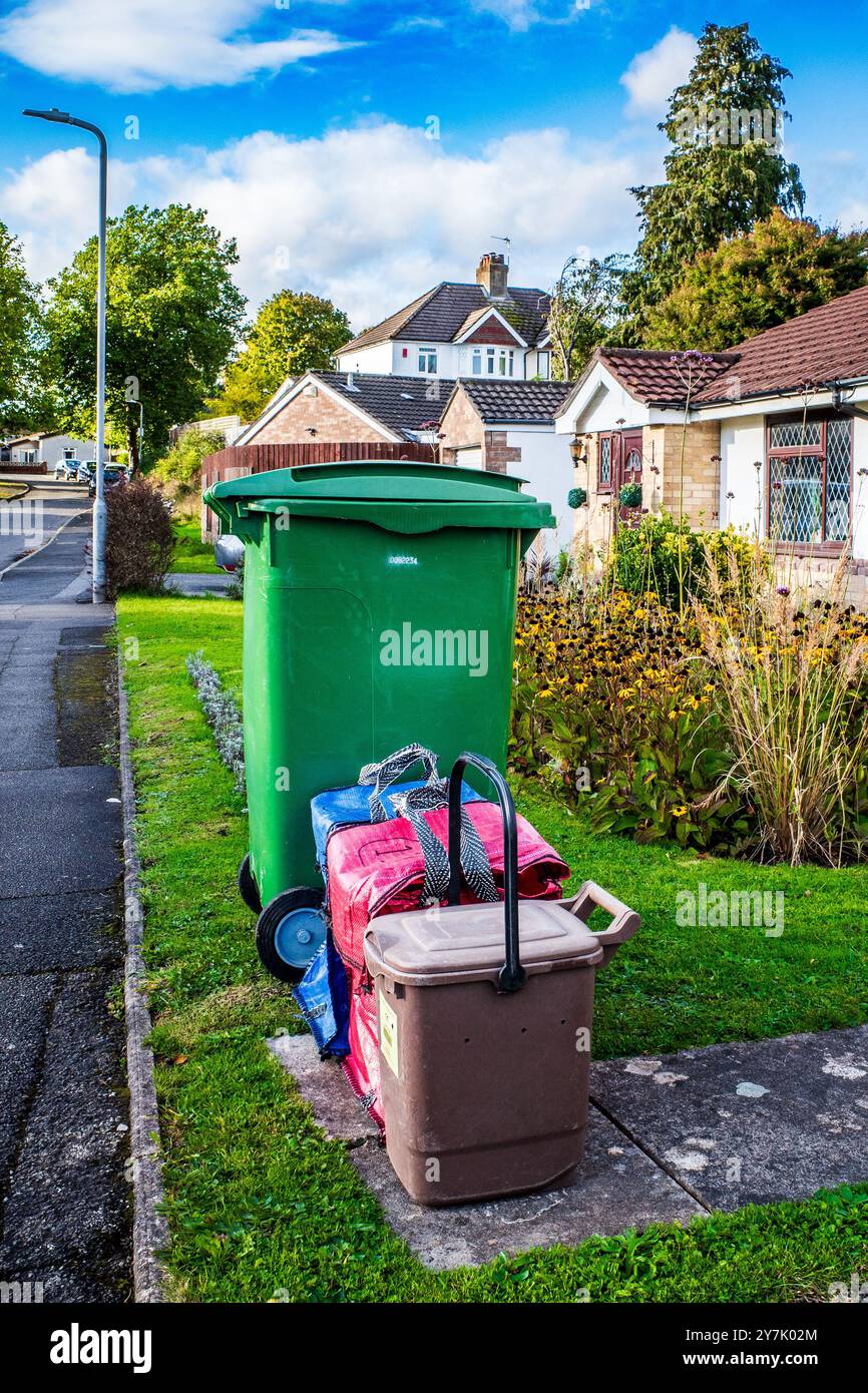 Refuse for recycling awaiting collection sorted into coloured garden, paper and metal bins and bags in a suburban road in Cardiff, Wales, UK. Waste. Stock Photo