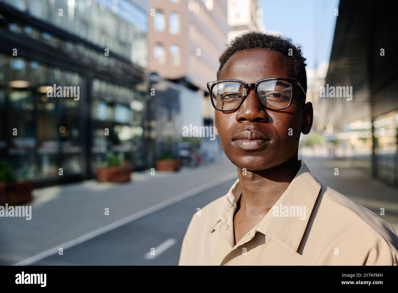 Young Black Man In Eyeglasses Standing Outdoors Stock Photo