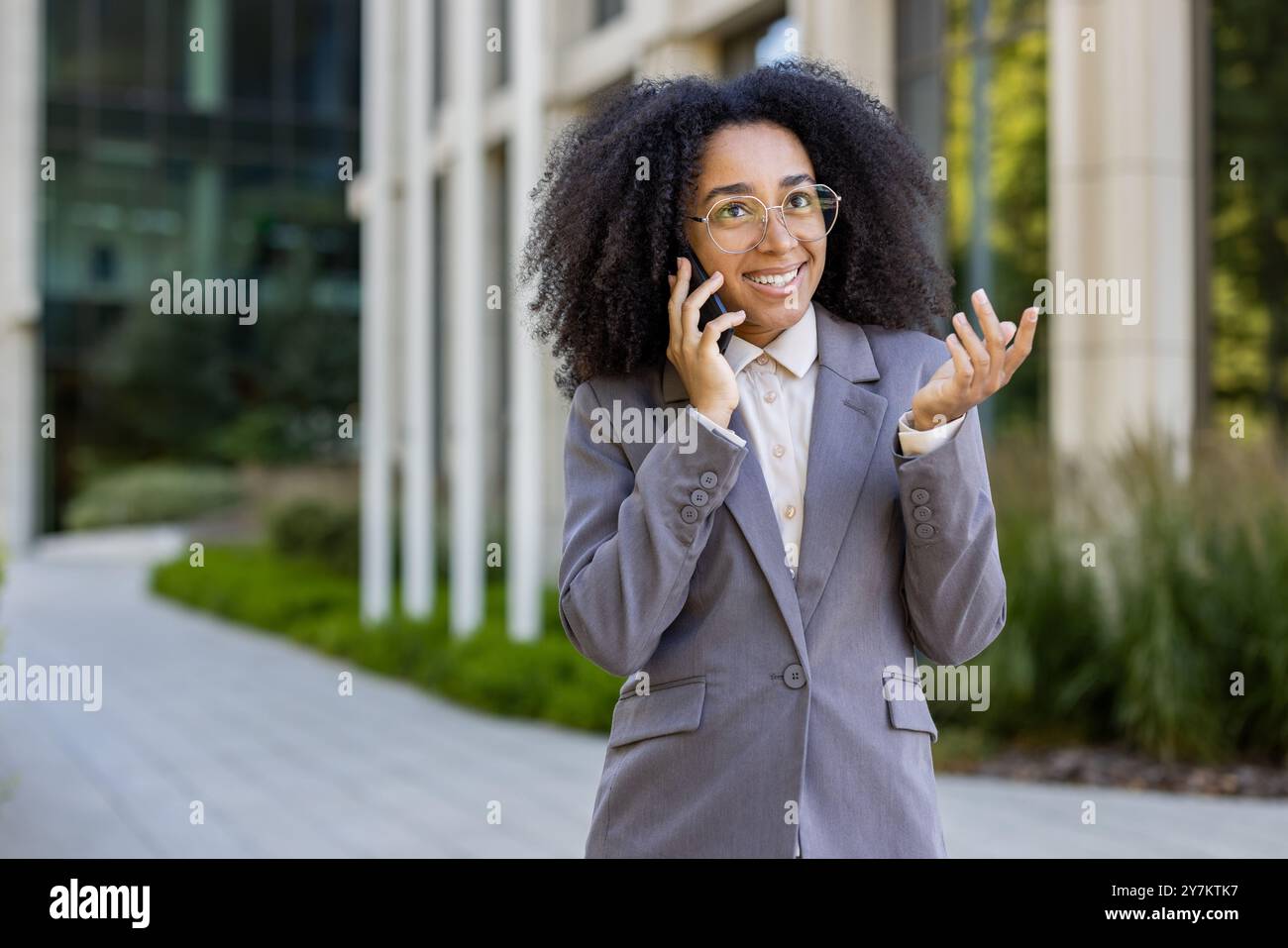 African American business woman in professional attire talking on phone ...
