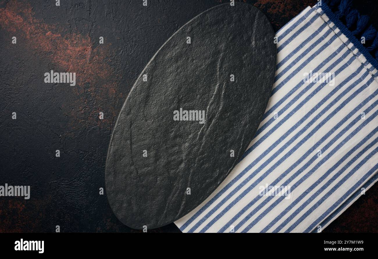 Oval stone kitchen board on black background, top view. Copy space Stock Photo