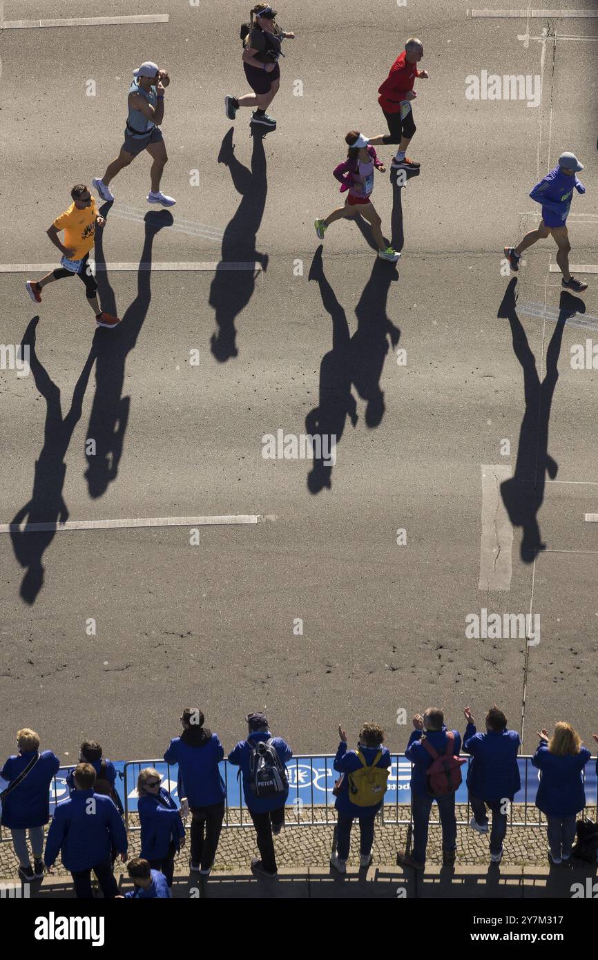 Marathon runners and their shadows at the 50th BMW Berlin Marathon 2024