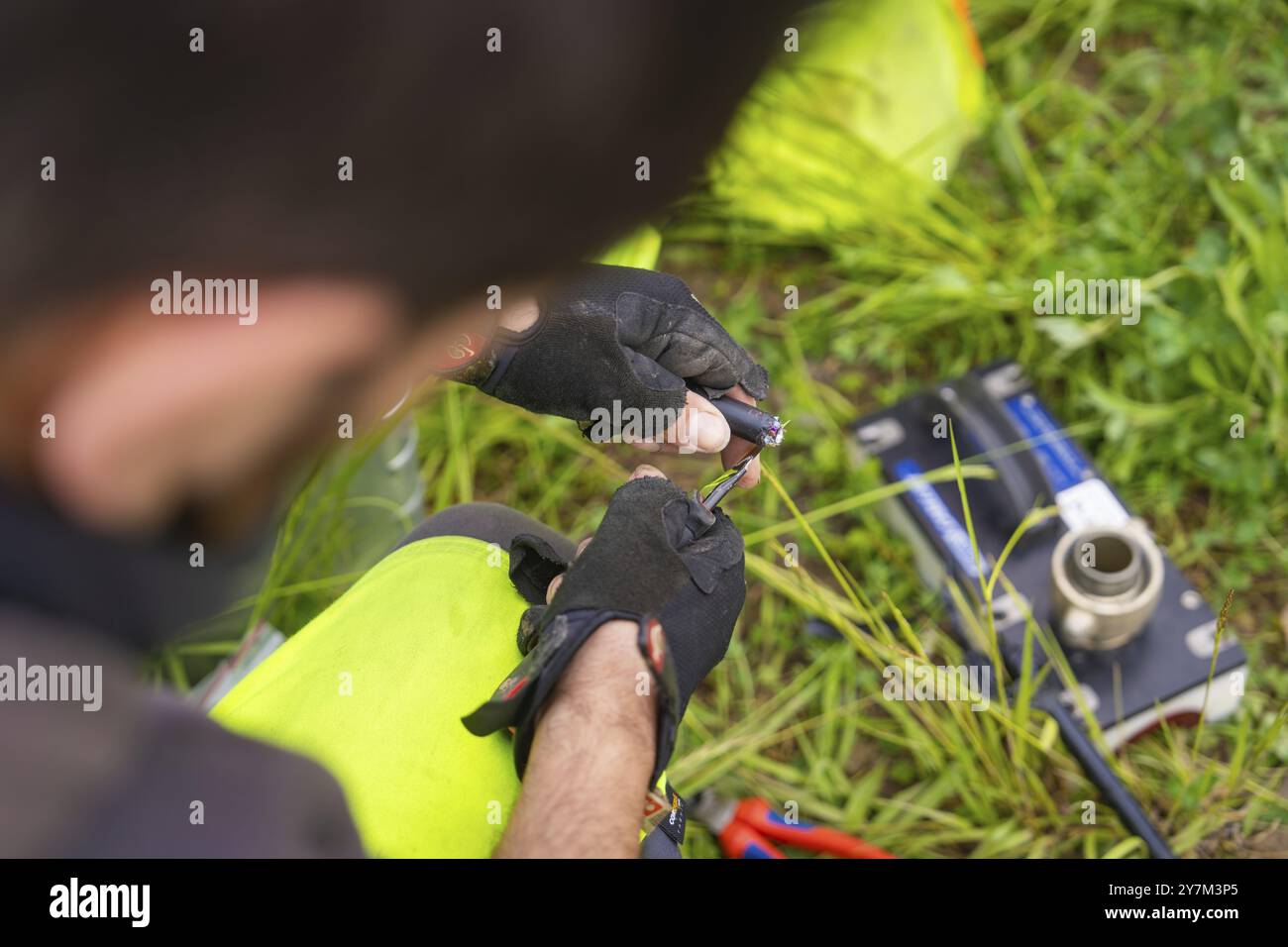 Worker in gloves holding a cable and working with it in a meadow, fibre optic installation, district of Calw, Black Forest, Germany, Europe Stock Photo