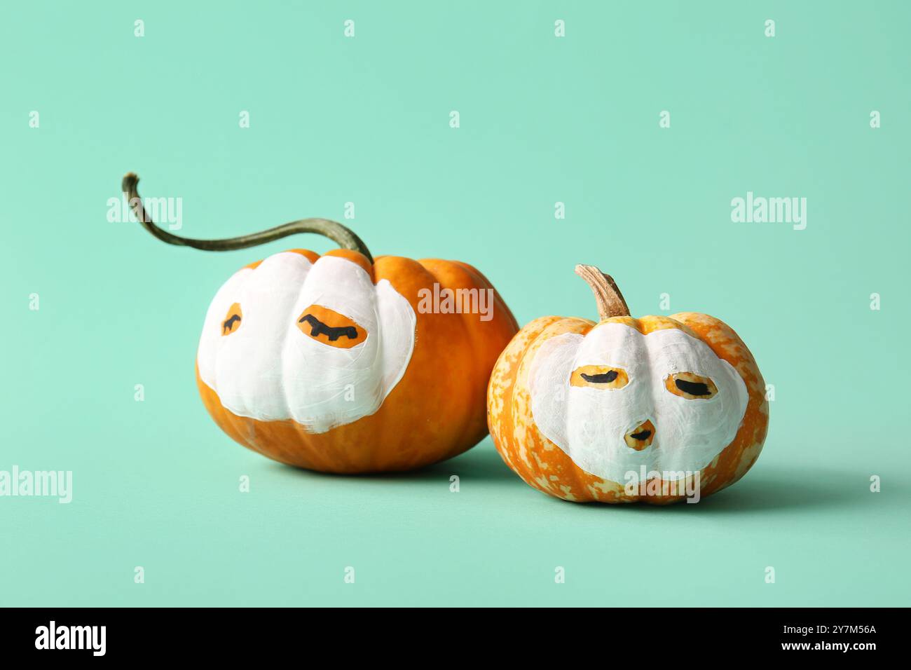 Funny pumpkins with drawn faces and cosmetic masks on color background ...