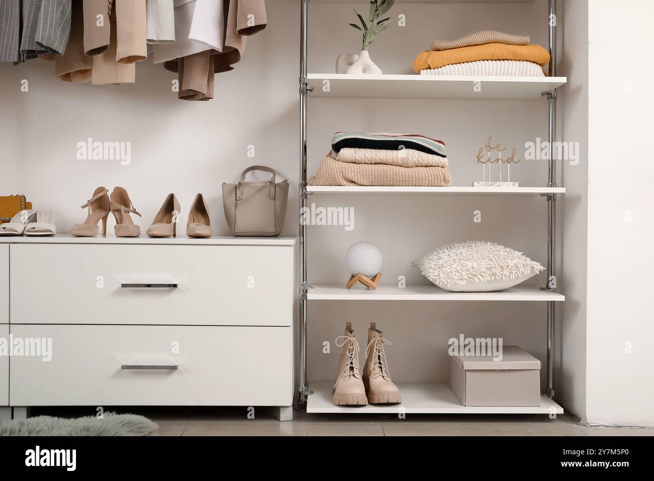 Wardrobe with shelves, female clothes and shoes in walk-in closet Stock Photo