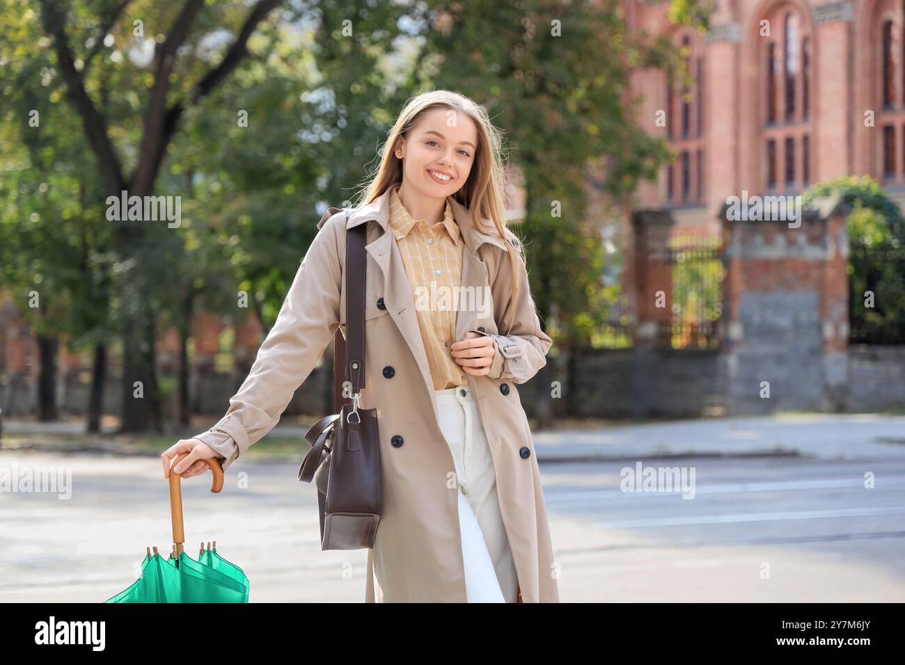 Pretty young woman with umbrella on city street Stock Photo - Alamy