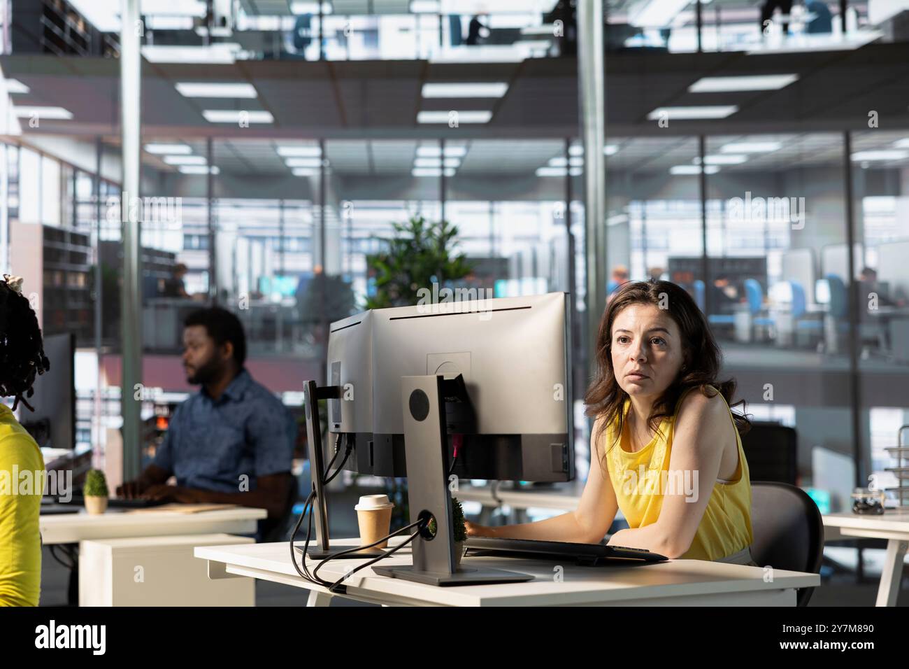 IT employees in office working at computer desks, testing and deploying programs and systems. Programmer and developers checking code on desktop PCs, solving tasks in workspace Stock Photo