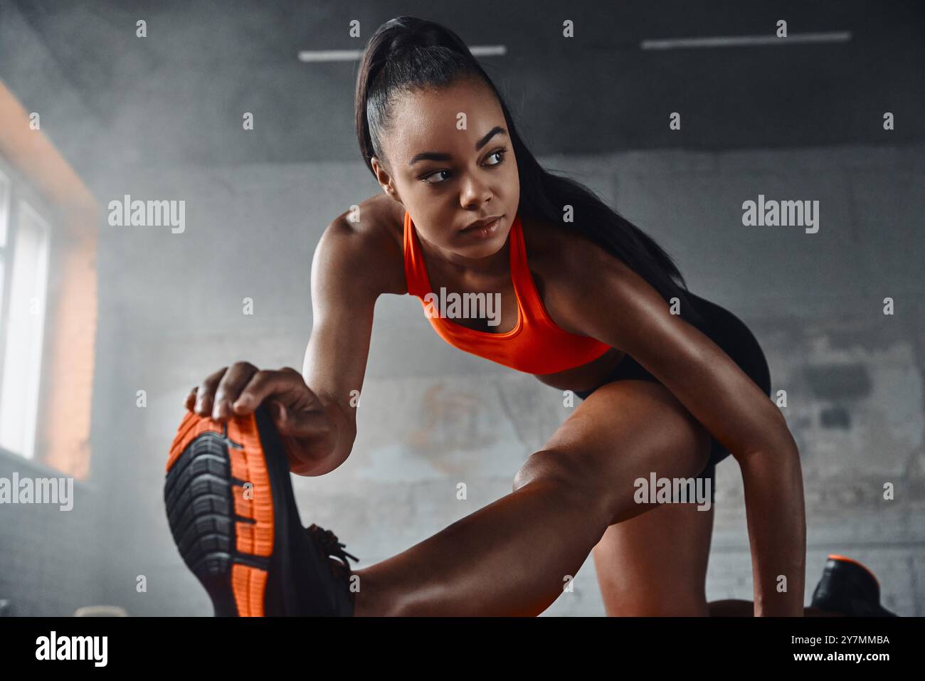 Attractive young African woman doing stretching exercises in gym Stock ...