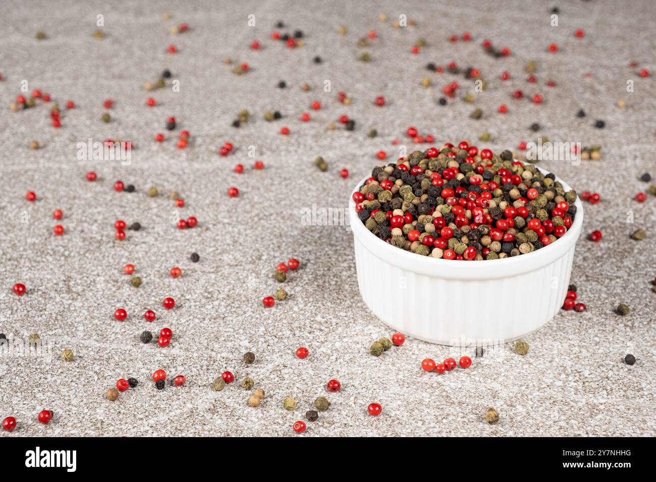 Multicolored peppercorns on a stone gray background Stock Photo