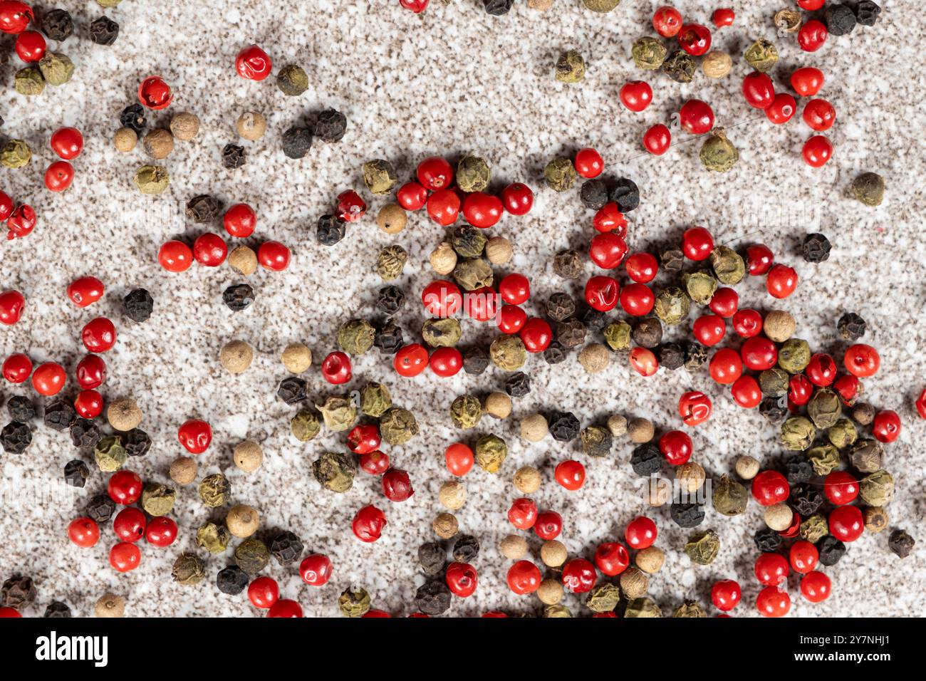 Multicolored peppercorns on a stone gray background Stock Photo