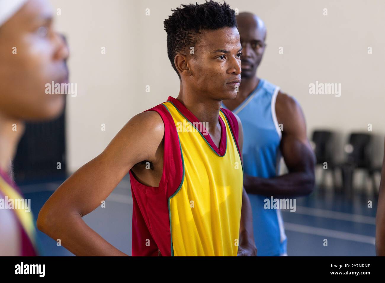 Diverse Basketball players standing on court, focusing on game strategy during practice Stock Photo