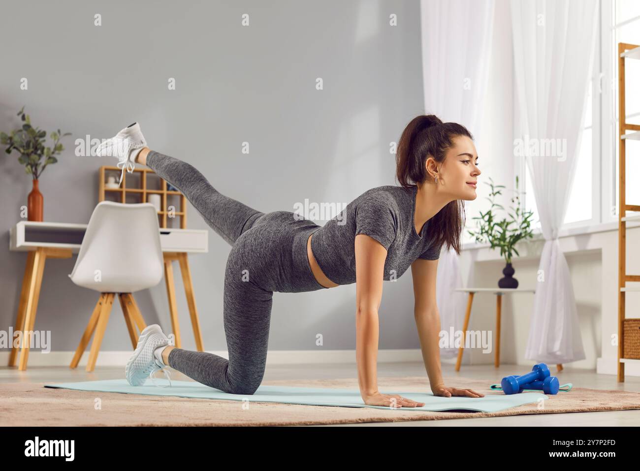 Young Woman Working Out At Home And Doing Stretching Exercise Stock Photo