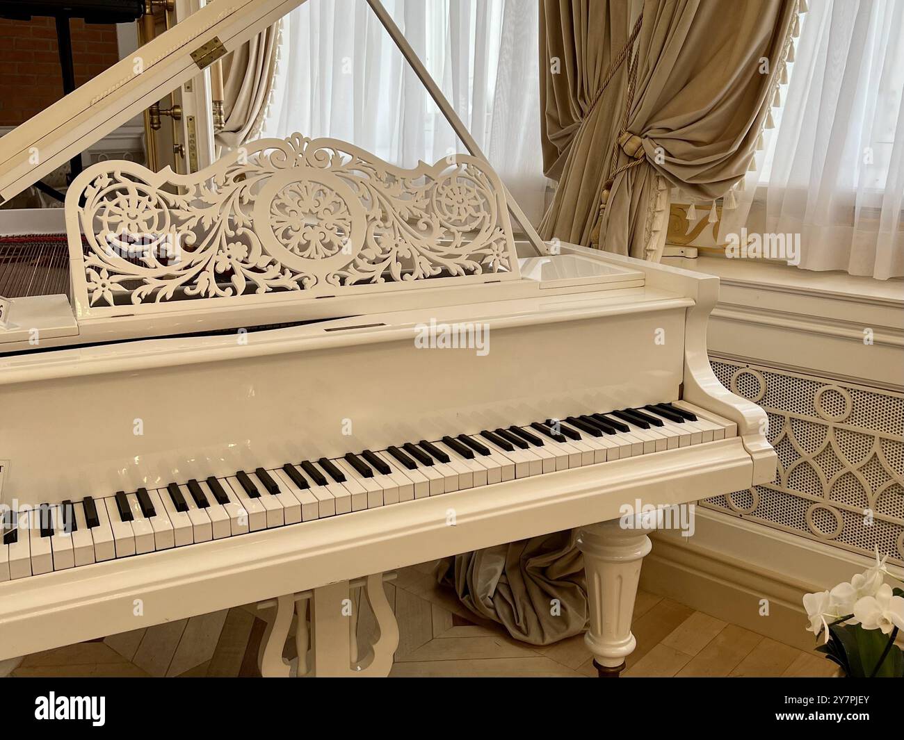 White grand piano in a beautiful room. Vintage style grand piano. Music room, parquet. - Smartphone Captured Stock Image