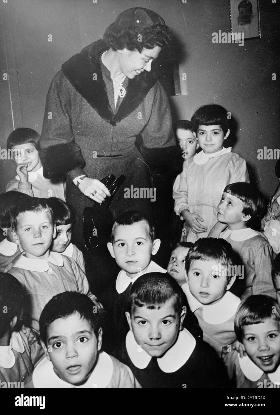 QUEEN FREDERIKA WITH HER TINY SUBJECTS. On 2.2.54, 26 moppets of St Andrew's orphanage at Kalamaki, near Athens, stare wide-eyed and open-mouthed at the photographer, but one of the youngsters could not tear his eyes away from Queen Frederika of the Hellenes, who loves children. She later laid a cornerstone of a new children's hospital nearby. 4/EM/74318. International News Photos. Stock Photo
