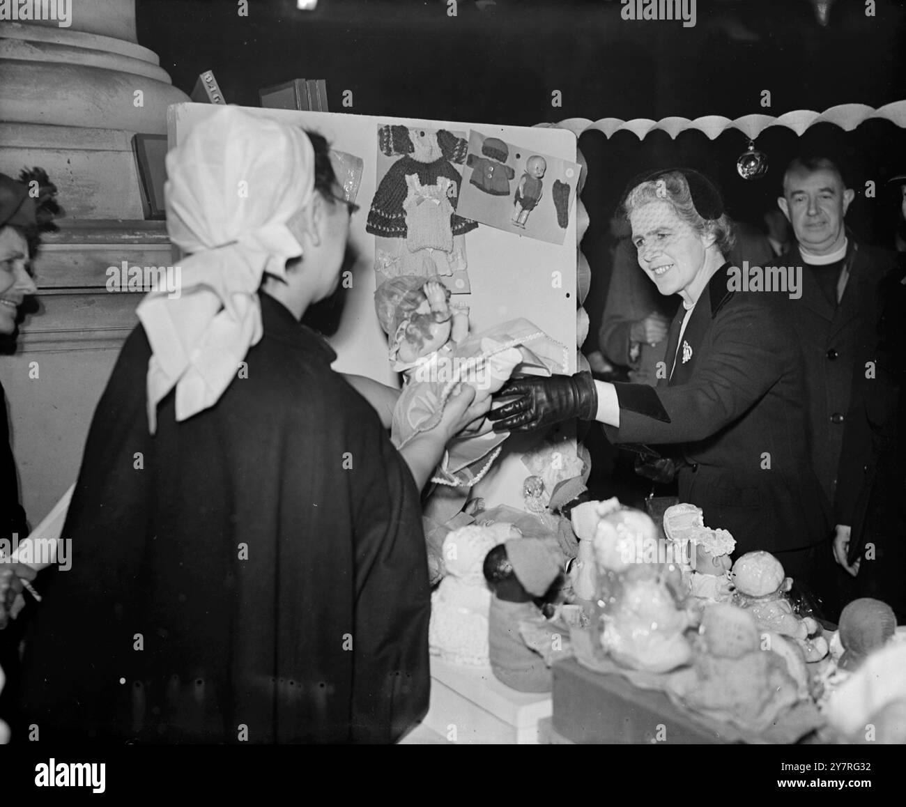 The Lady Mayoress shops at the fair. On December 3, 1953, the City of London British Red Cross Society's Christmas Fair was opened by the Lady Mayoress, Lady Bowater, at the Royal Exchange this morning. The stalls have been furnished with goods donated from city companies, firms, and markets. An I.N.P. photo shows Lady Bowater buying a doll at a toy stall in the Christmas Fair, which she opened this morning. Picture by John Byworth. 526/special/PJ/73050. International News Photos. Stock Photo