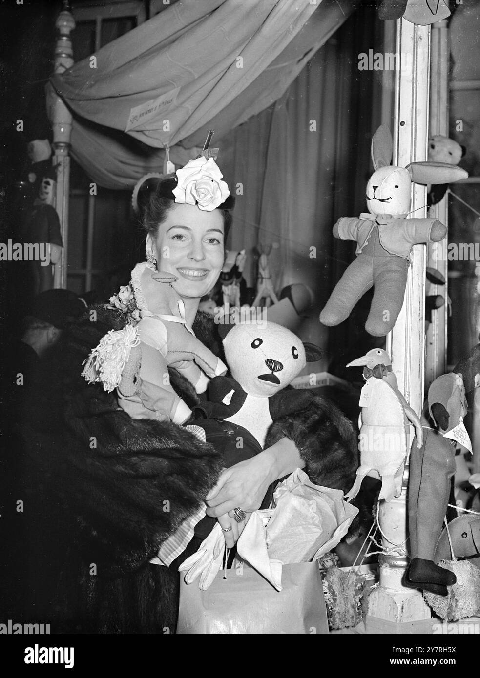 A star goes shopping. On 5.11.53, Miss Valerie Hobson, star of the London production of 'The King and I,' joined Marshal of the Royal Air Force, Sir John Slessor, in opening the Y.W.C.A. Christmas Fair at the Hyde Park Hotel, Knightsbridge, London. Afterwards, she bought toys at the nursery stall. I.N.P. photo shows Valerie Hobson leaving the nursery stall with her arms piled with toys she has bought. Picture by Aubrey Hart. 546/special/PJ/72379. International News Photos. Stock Photo