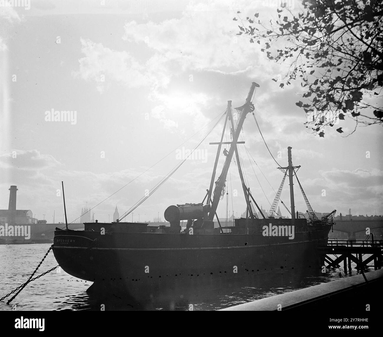 The discovery is prepared for the voyage which may be her last 26.10.53. Captain Scott's famous ship, the Discovery, in which he sailed to the South Pole, is being given up by the Boy Scouts Association which has been using it as a training ship. The Discovery is to be taken to the London Graving Dock, Poplar, for an inspection of its underwater bodywork. If this is found to be in good condition the Admiralty will take it over - if not the ship may be scrapped. I.N.P. photo shows a workman is silhouetted on the mast which is being removed to enable the ship to pass under the low bridges on its Stock Photo