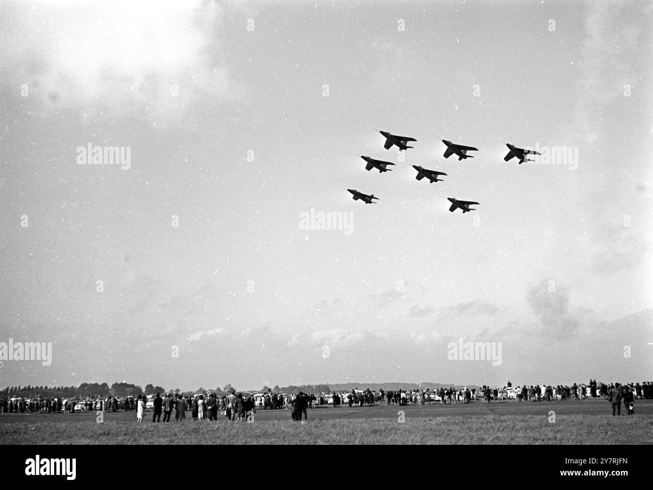 BALLET OF THE SKYBiggin Hill, Kent, England, UK : In the formation of amazing exactitude, the flight of Gnat trainers piloted by the Red Arrows into the sky, as spectators watch below. 17 May 1965 Stock Photo