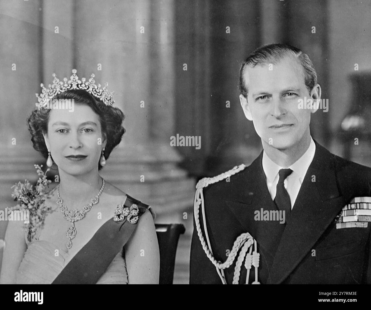 TO RELEASE ON 26 JANUARY, 1954. Royal Command Portrait by Baron: H.M. THE QUEEN & H.R.H. THE DUKE OF EDINBURGH. The Queen is seen in a yellow tulle evening gown decorated with sprays of mimosa. She is wearing the blue Ribbon and Star of the Garter. Her necklace is a wedding present from the Nizam of Hyderabad. The tiara is also a wedding present from Queen Mary. The bow brooch and drop earrings are set with diamonds. The Duke is seen in the uniform of Admiral of the Fleet. The portrait study was taken in the Grand Entrance in Buckingham Palace. Study by Baron, please acknowledge.  Internationa Stock Photo