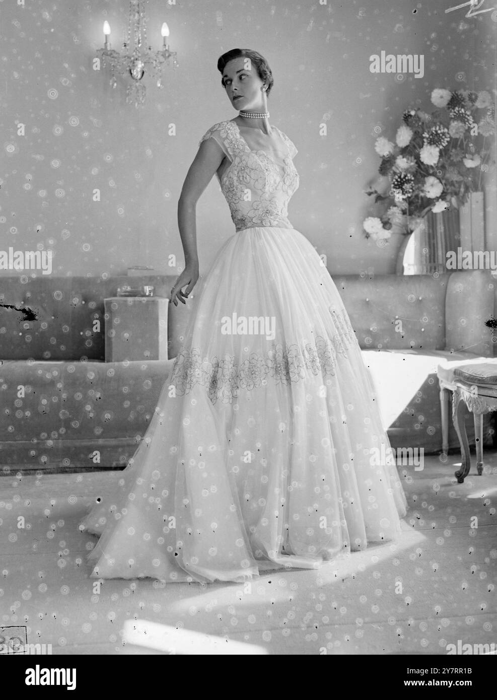 HARTNELL'S AUTUMN COLLECTION - 3.9.53. - The Hartnell autumn collection, presente ter the - splendour and elaboration of the Coronation collection, - turns to the simple lines of practical clothing. - I.N.P. photo shows Wild Rose, an evening gown of pink tulle - with appliqued pink thread roses and blue - china. - Picture by Jack Davies - PJZ70913 - (19) - International News Photos Stock Photo