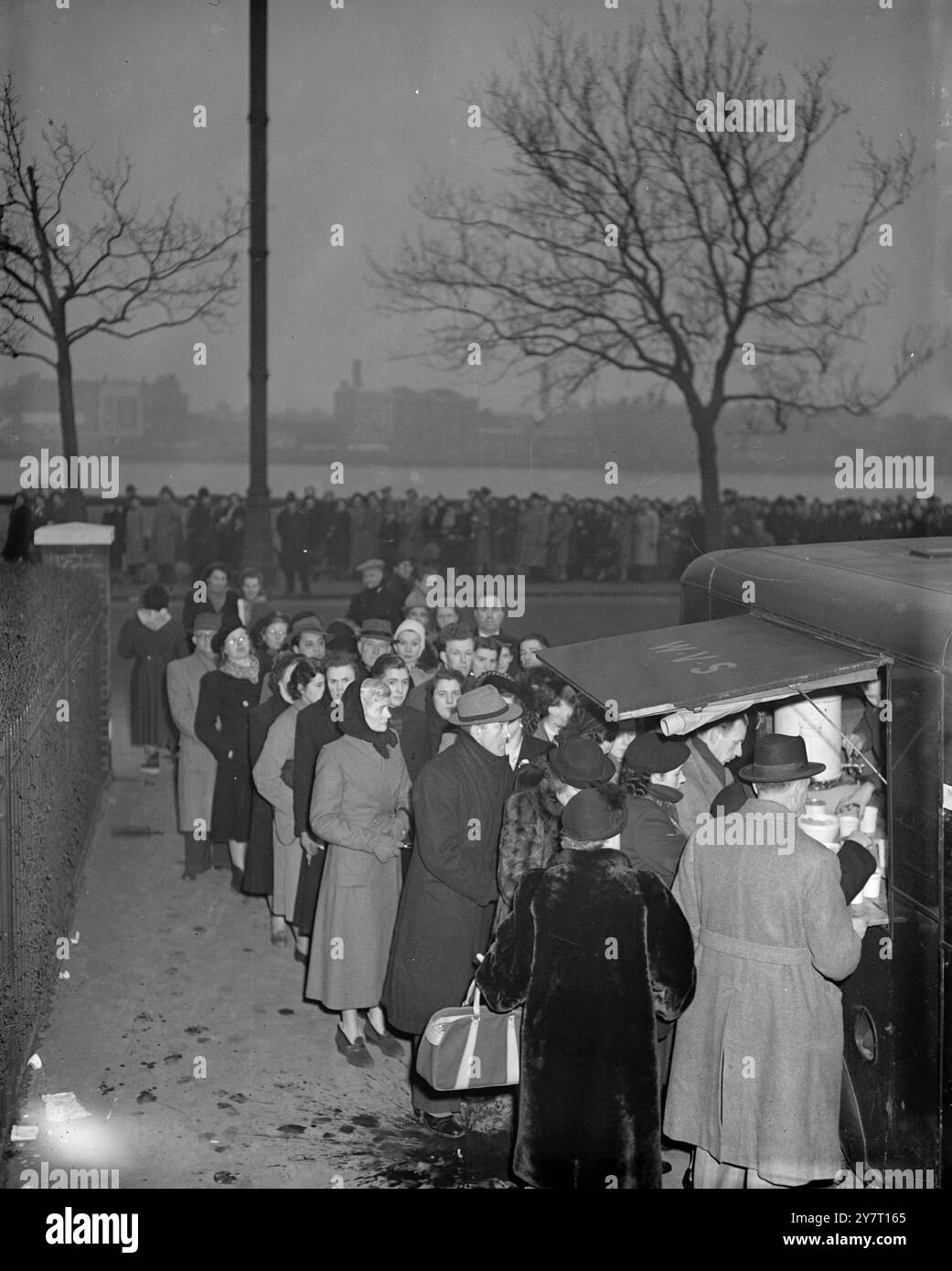 Still they come to pay homage ……These queuers found a hot drink a welcome respite when it was supplied from a mobile canteen by members of the WVS – they had been lining up for many hours to pay their last respects to King George VI who is lying-in-state at Westminster Hall 13 February 1952 Stock Photo