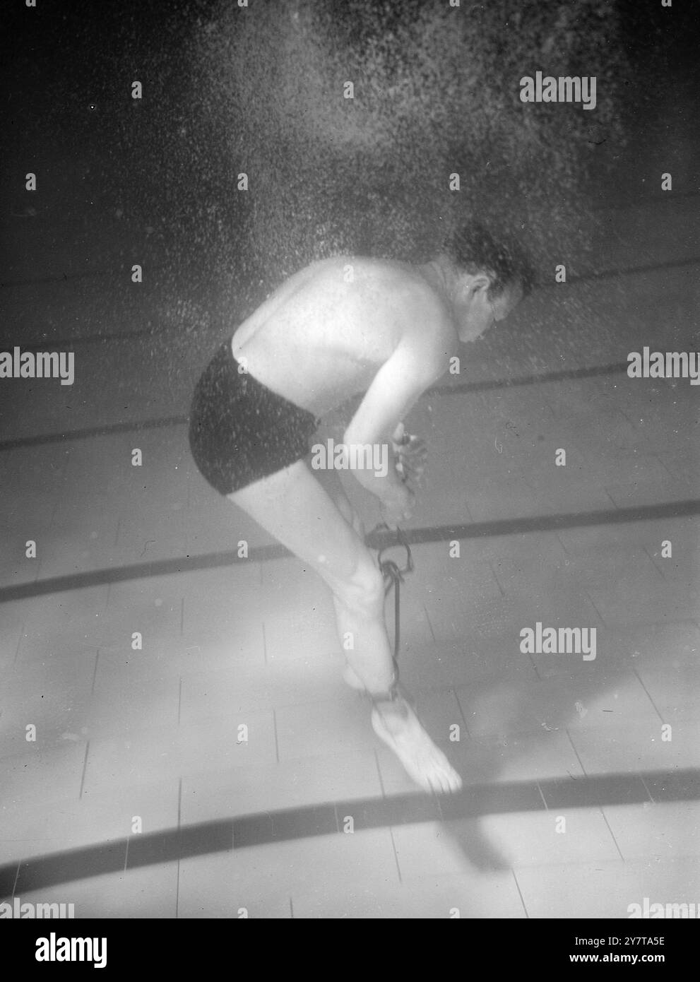 UNDERWATER ESCAPE THAT VIEWERS WILL NOT SEE   18 May 1950    Televiewers will not see the underwater battle against death recorded in this below the surface picture at Layton Baths, Esex as escapologist Robert Harbin, surrouded by clouds of air bubbles struggles to escape from handcuffs and leg irons.  Harbin is rehearsing for the under water escape to be featured in a TV aqua show on 19 May.  Viewers will see him placed in a weighted sack and thrown into the water.  Within a few minutes, he will be back on the surface but the actual escape under water will not be televised.  Harbin risks his Stock Photo