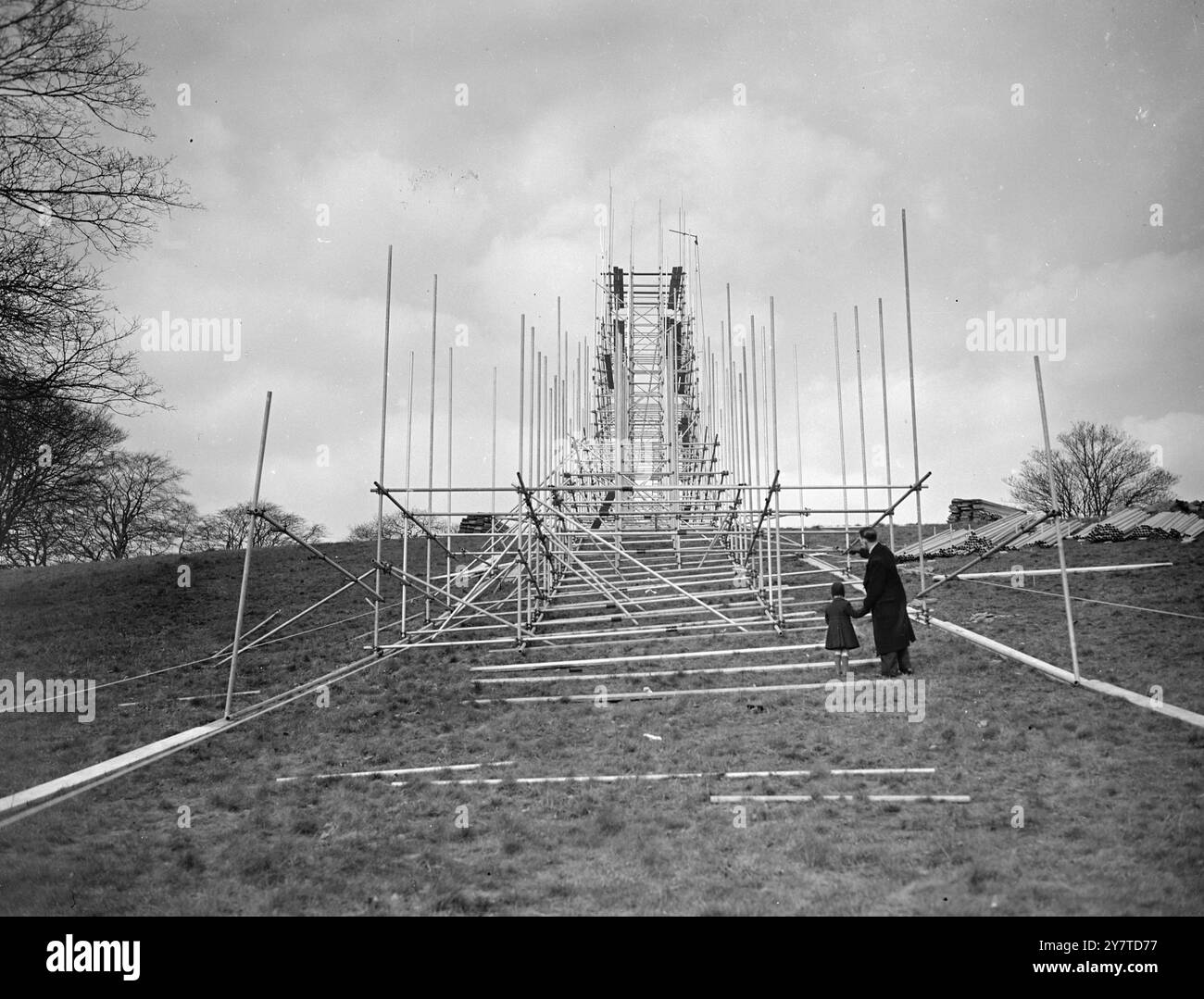 HAPPY HAMPSTEAD FOR SKI-JUMPERS  Thrills never enjoyed by Londoners before are promised-by this  ' scenic railway ' -  for ski experts only - now being built on Hampstead heath . It is to be the scene of London's first ski-jumping competition on March 24 and 25 . When the scaffolding has been completed it will be overlaid with snow imported from Norway by refrigerator ship . The competition is to be an Anglo-Norwegian event in which jumpers from Oxford and Cambridge Universities and a team of 25 of Norway's top-ranking exponents will compete for the London Cup . Organisers of the Competition a Stock Photo