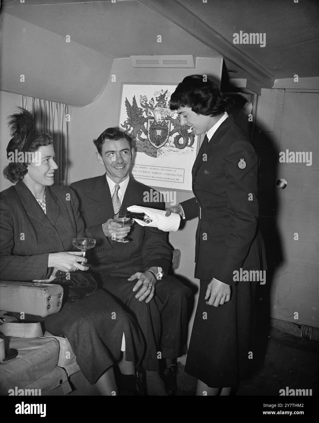 Flying honeymooners claim their champagneFor honeymoon couple flying the Atlantic in their aircraft , BOAC , provide a bottle of champagne.  First couple to confess to being honeymooners and to claim the free bubbly are Mr and Mrs Thomas Reeves seen being served with the champagne on board a Montreal-bound BOAC Stratocruiser at London Airport.  Mr Reeves is from Staines , Middlesex.  His bride was formerly from Toronto , Canada . 5 January 1951 Stock Photo