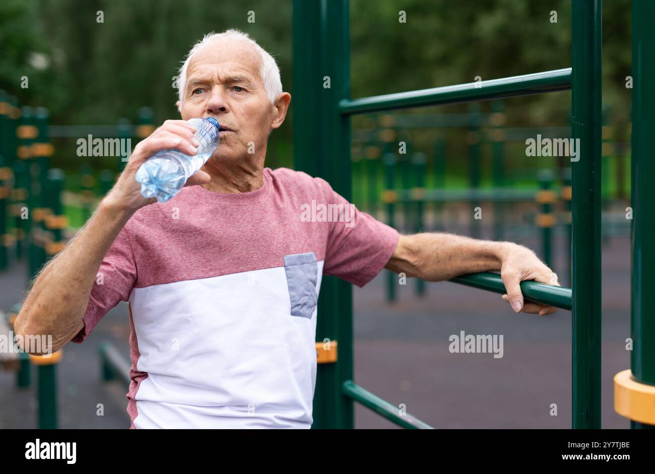 Old man drinking water in outdoor workout station Stock Photo - Alamy