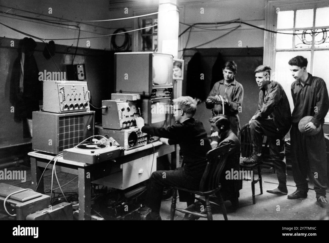 London's first closed circuit television broadcast of a soccer match takes place tonight when the whole of the Workington v Millwall Third Division match will be screened live at Millwall's ground - The Den. Today's picture shows some of the Millwall's younger players watching the installation of equipment in their dressing room, Workington stadium at Borough Park, Cumbria, England.28 Janaury 1966 Stock Photo