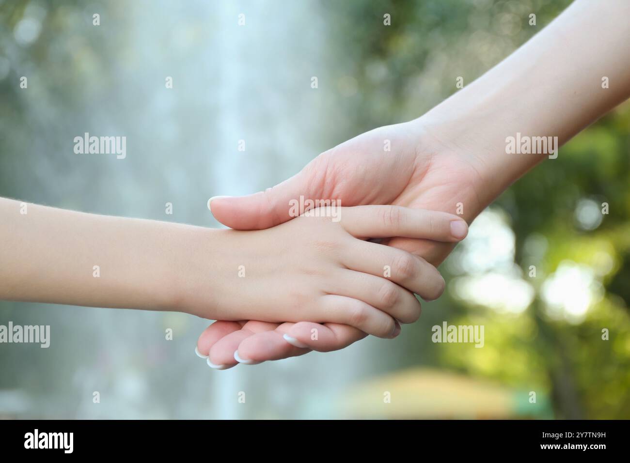 Mother and daughter holding hands in park, closeup Stock Photo - Alamy